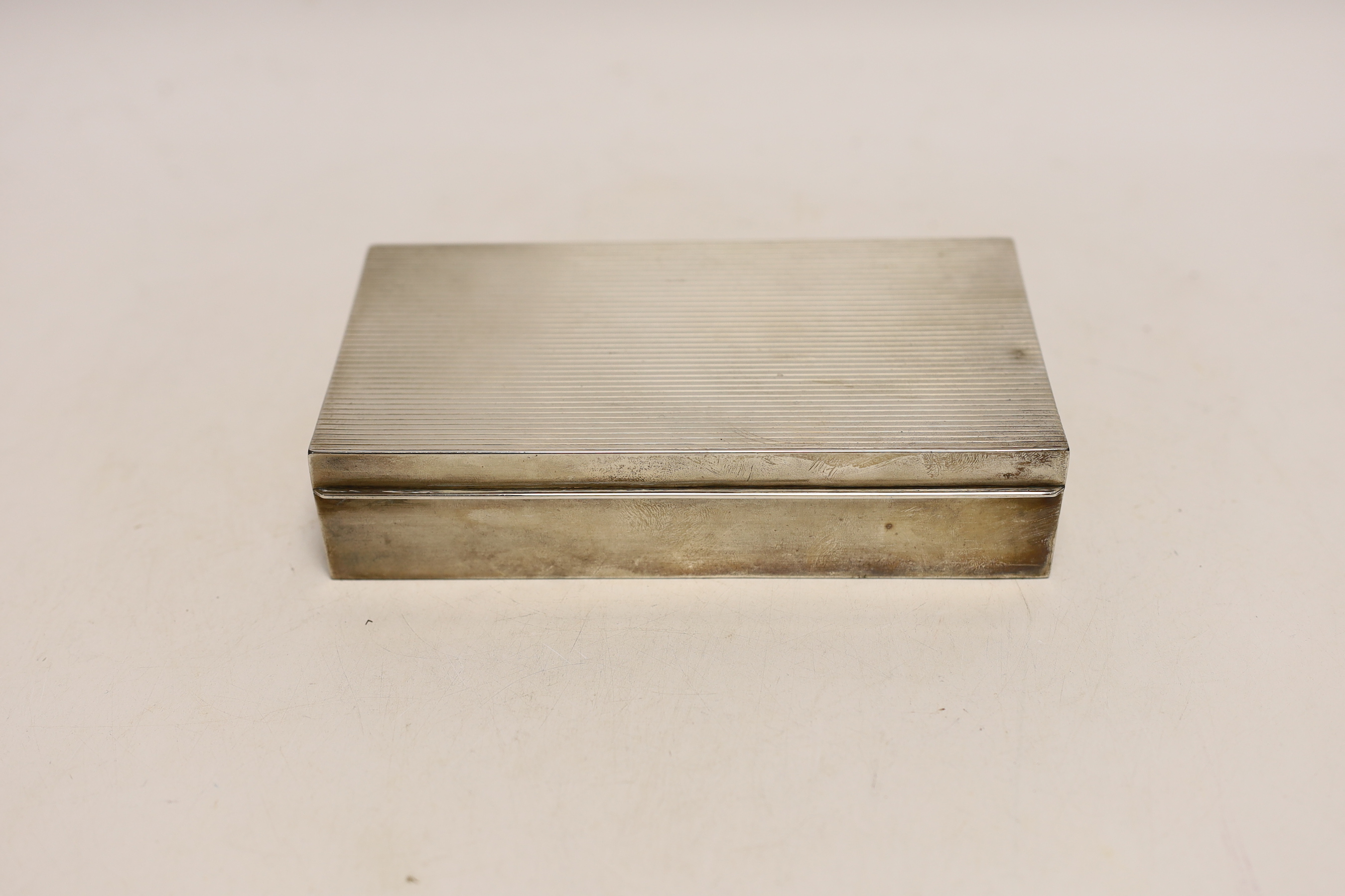 A sterling 925 mounted rectangular cigarette box, with reeded cover, 17.4cm and a similar unmarked cigarette lighter.